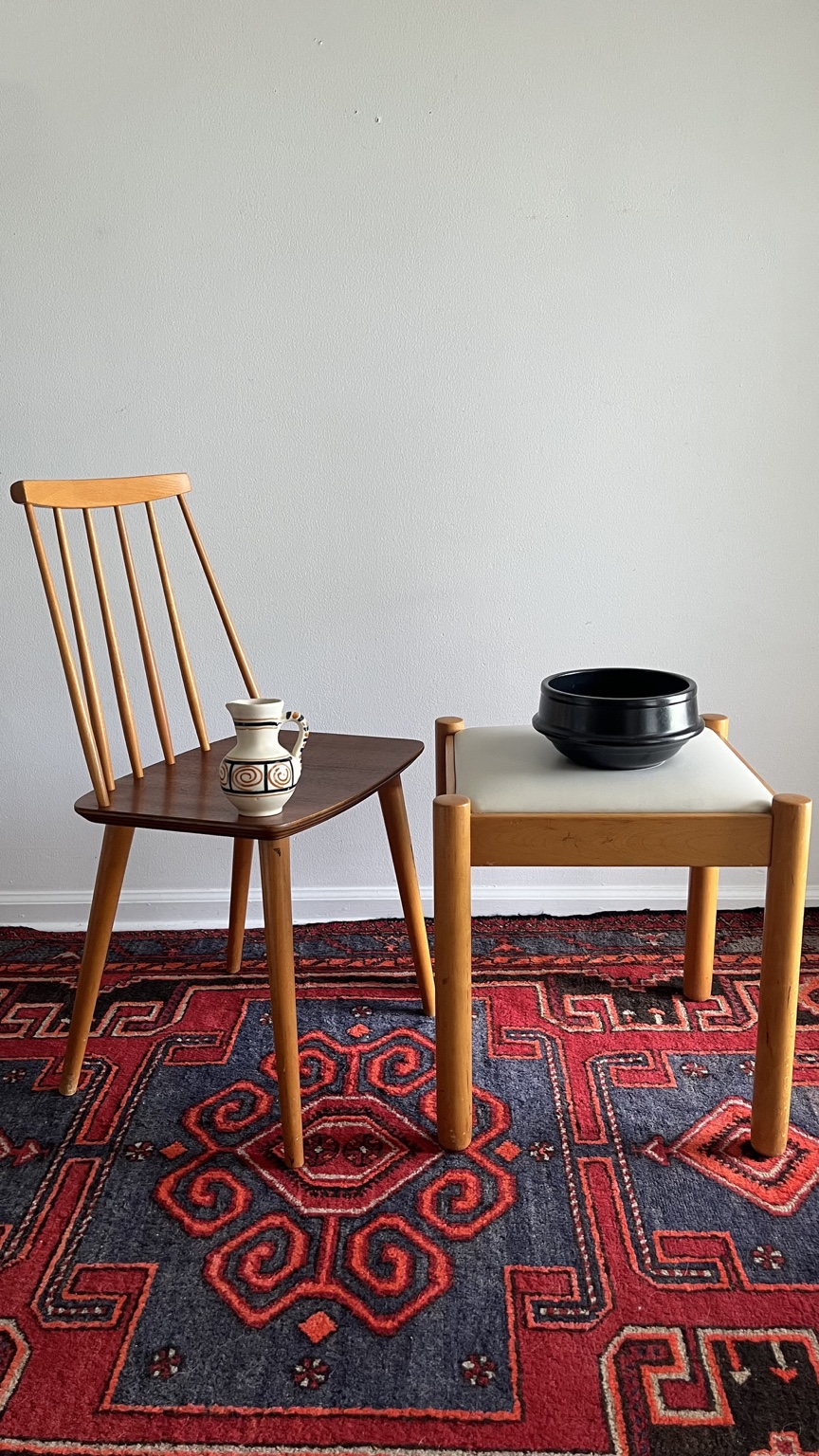 Vintage spindle-back chair and upholstered wood stool styled with pottery at Objet48
